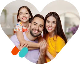 A smiling family with a father, mother, and daughter posing together inside a heart-shaped frame.