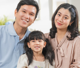 Family of three smiling at home, representing health coverage access under the Affordable Care Act