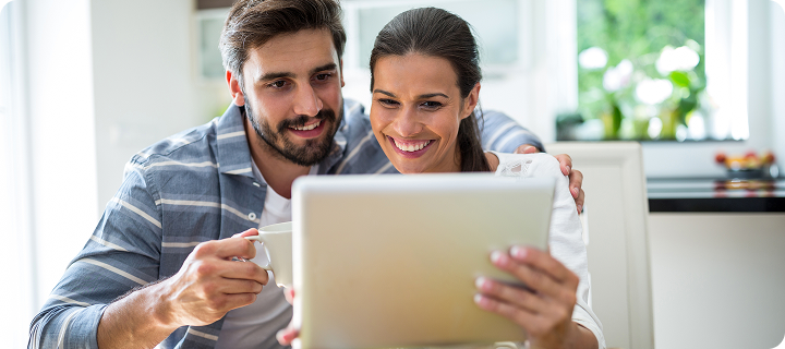 Couple at home using a tablet to research what is the difference between ACA vs private health insurance