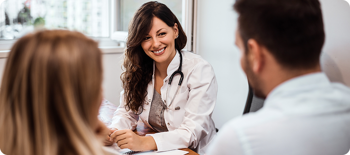 Doctor consulting with patients in an office, illustrating healthcare services under the Affordable Care Act