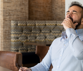 Tired Hispanic Man Working Remotely from Office experiencing afternoon slump