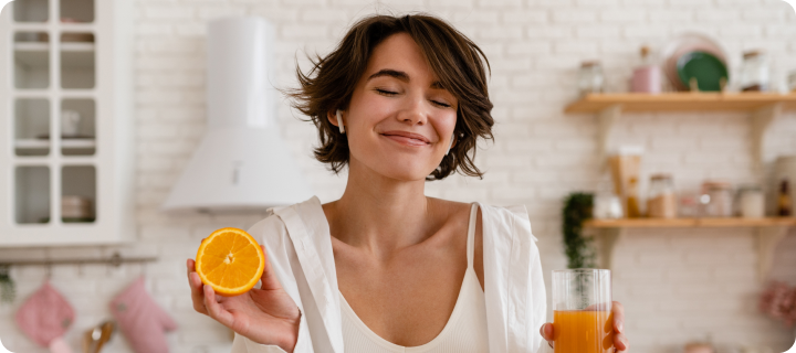 young pretty woman cooking at home, morning kitchen, healthy food, cutting fruits oranges, making orange juice, managing afternoon slump with wellness