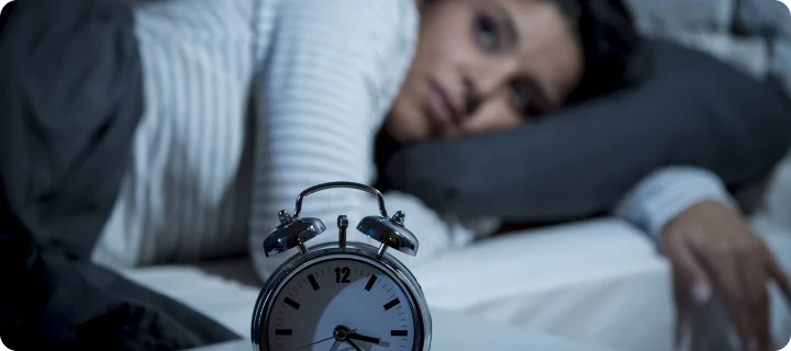 Young Hispanic woman at home bedroom lying in bed late at night trying to sleep suffering insomnia sleeping disorder or worried and stressed