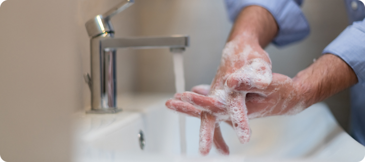 Person washing hands with soap under running water, illustrating handwashing and common medical myths about hygiene and germ prevention.