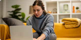 Young adult researching health insurance and healthcare options online while using a laptop from the comfort of home.