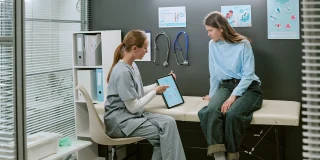 Healthcare provider discussing fertility treatment options with a patient during a medical consultation about insurance coverage.