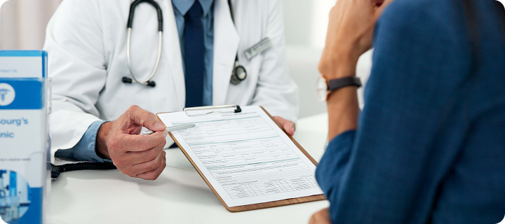 Doctor discussing health insurance paperwork with a patient during a consultation.