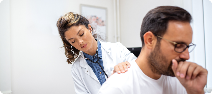 Doctor examines a coughing patient, highlighting Coverage Fox support during cold and flu season.