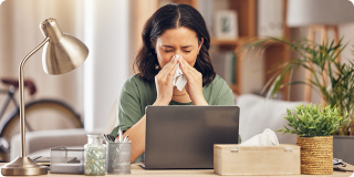 Woman with cold symptoms working from home, highlighting Coverage Fox during cold and flu season.