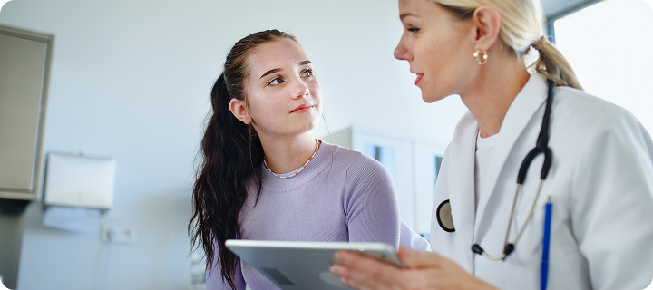 Young adult discussing health coverage with a doctor, representing Coverage Fox health insurance when turning 26.