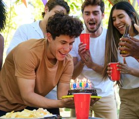 Young adults celebrating a birthday, representing the life change of turning 26 and reviewing Coverage Fox health insurance.